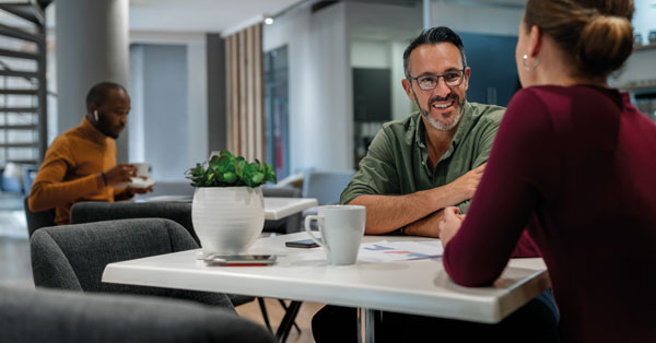 Two people facing each other, engaged in a discussion about applying for a job.